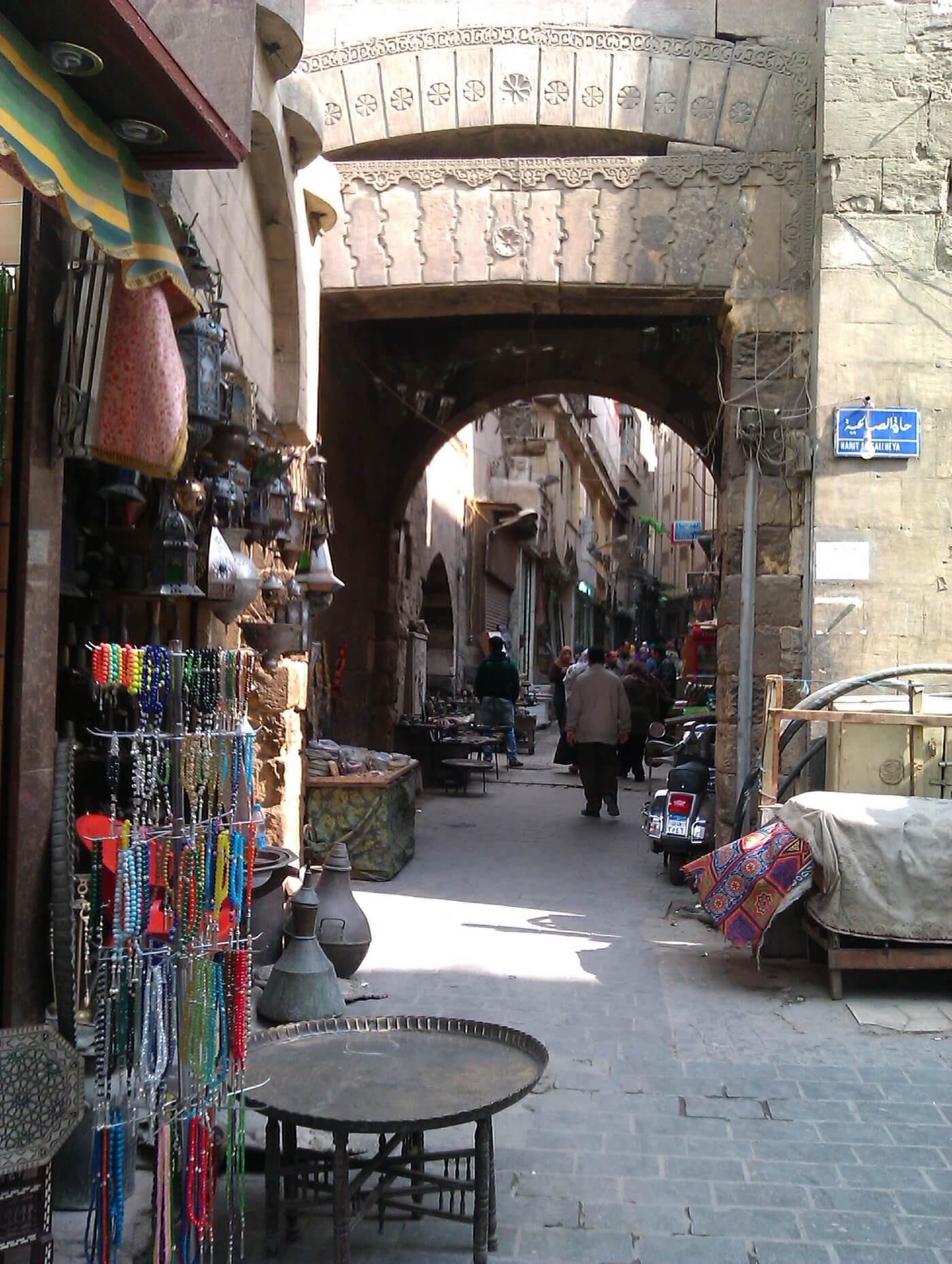 Calle comercial con puestos y viandantes en Khan el-Khalili