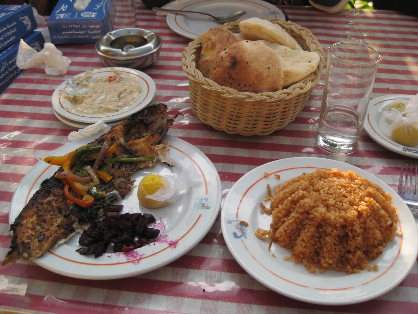 Pescado a la parrilla con arroz sayadeya en una mesa egipcia